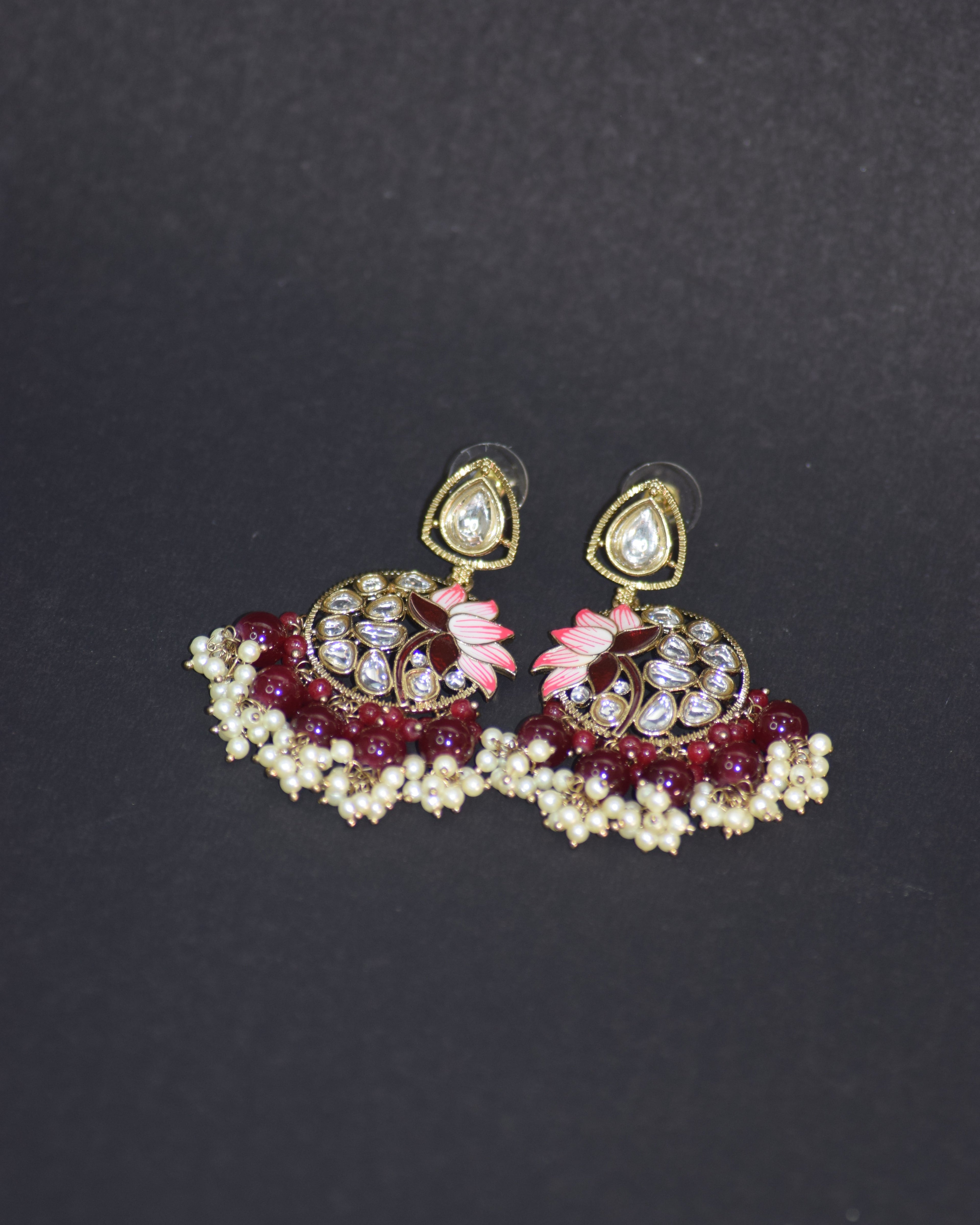 Jewelry set with earrings and a brooch on a dark background