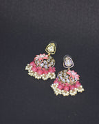 Pair of pink and gold earrings on a black background
