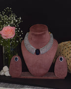 Pink jewelry display with necklaces and a rose on a dark surface
