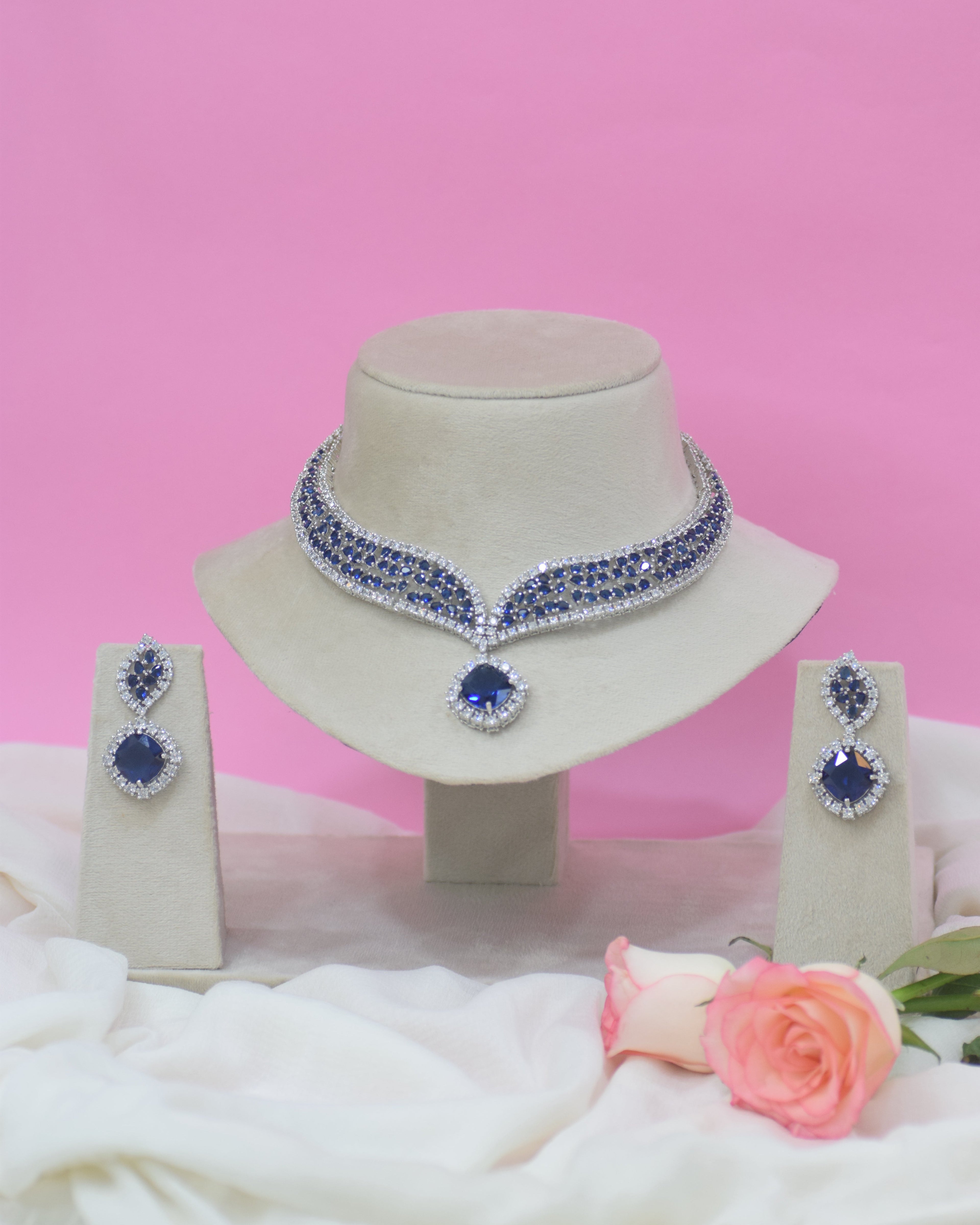 Jewelry set with earrings and a necklace on a pink background