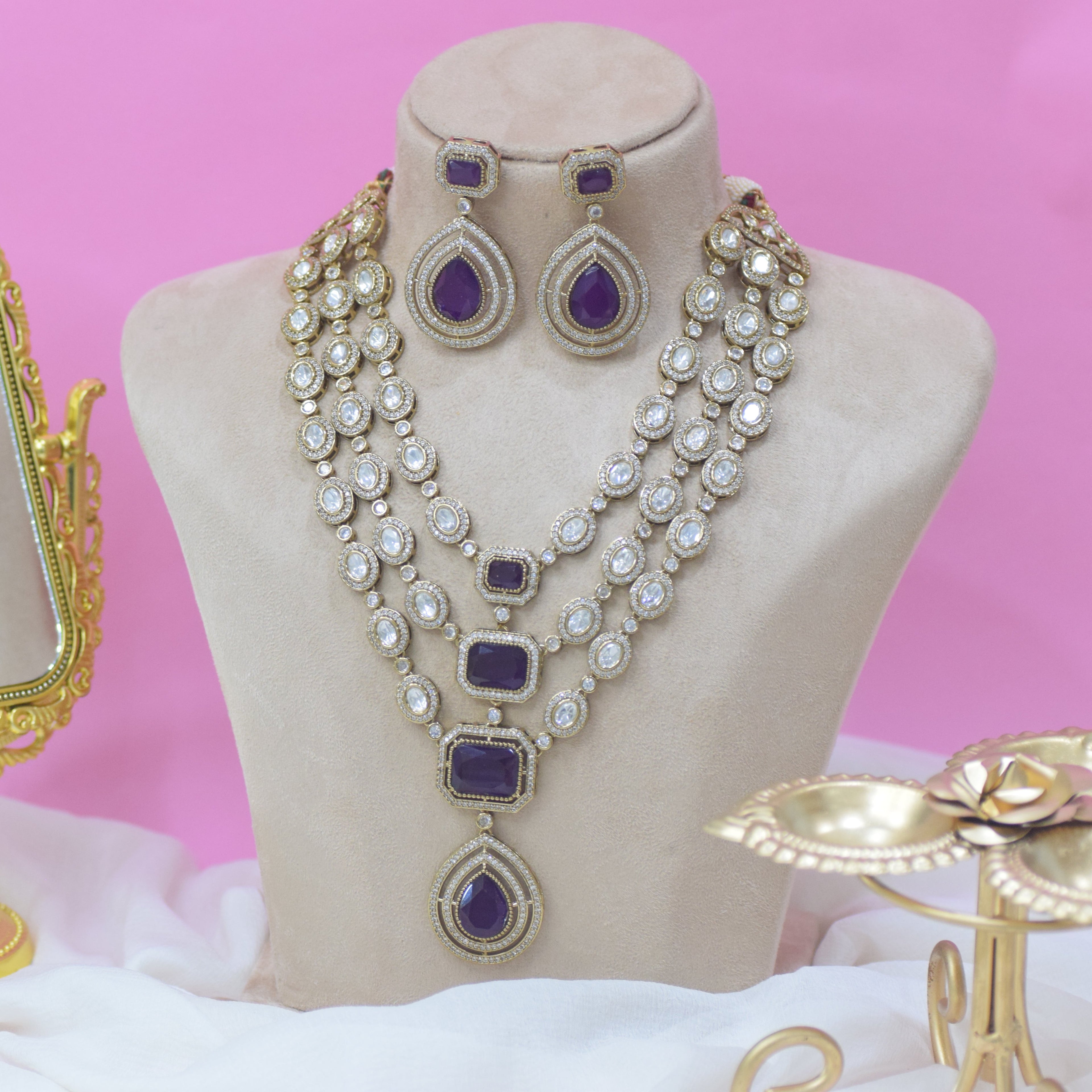 Jewelry set on a mannequin bust with a pink background