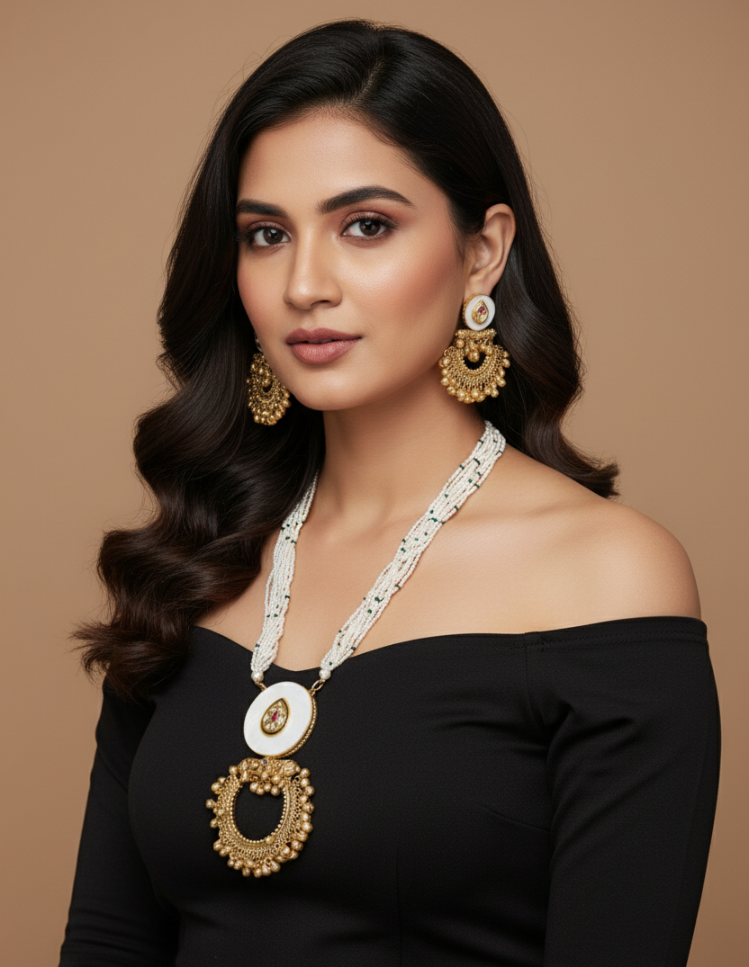 Woman wearing a black off-shoulder top with gold jewelry against a brown background