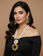 Woman wearing a black off-shoulder top with gold jewelry against a brown background