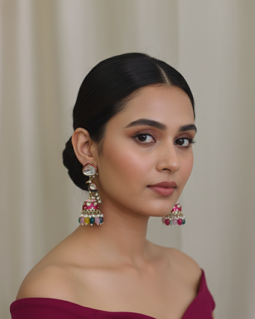 Woman wearing large, colorful earrings against a neutral background