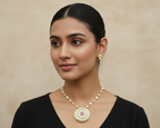 Woman wearing a pearl necklace and earrings against a beige background