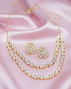 Gold necklace and earrings on a pink satin background
