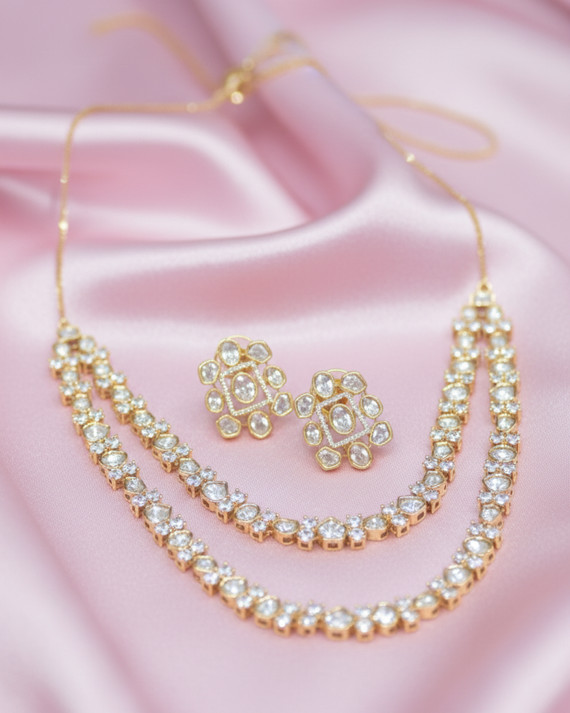 Gold necklace and earrings on a pink satin background