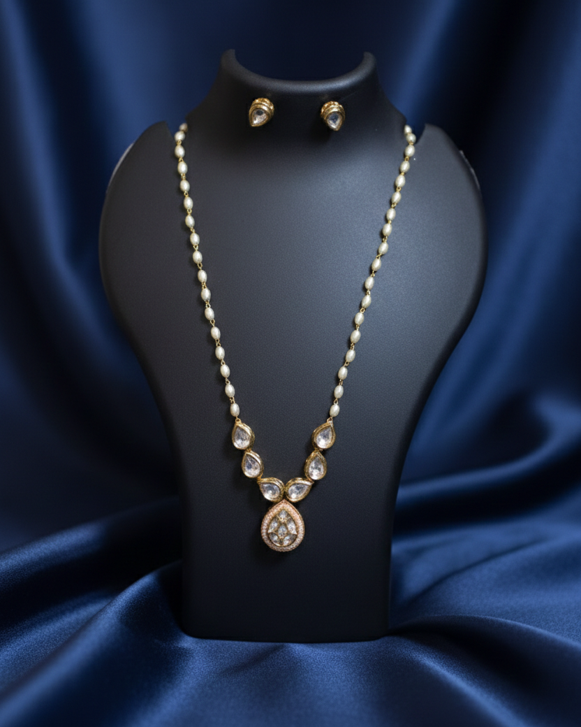Jewelry set including a necklace and earrings on a black mannequin against a blue satin background.