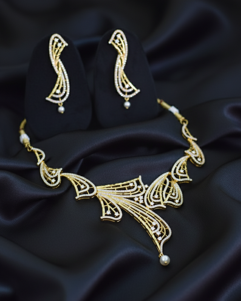 Gold necklace and earrings on black satin fabric