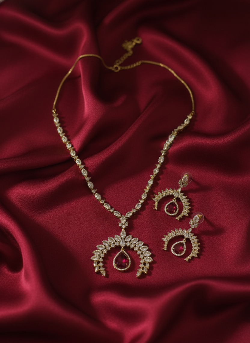 Gold jewelry set with necklace and earrings on red satin fabric