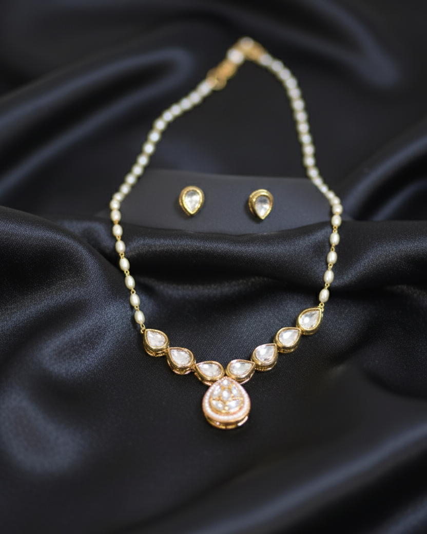 Pearl necklace and earrings on a black satin background