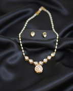 Pearl necklace and earrings on a black satin background