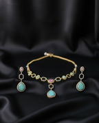 Gold jewelry set with turquoise stones on a black satin background