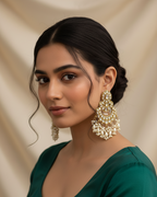 Woman wearing large, ornate earrings against a beige background