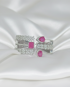 Jewelry brooch with pink gemstones on a white satin background