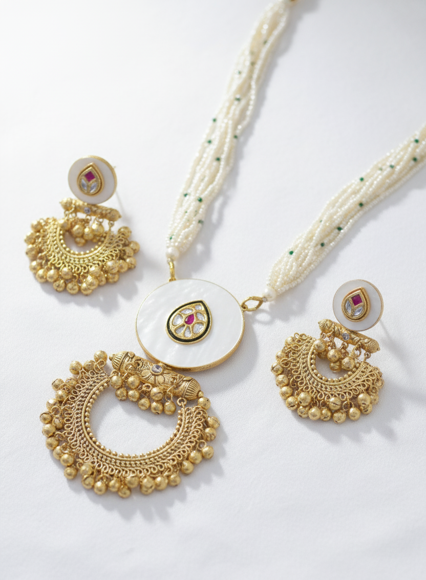 Gold necklace and earrings set on a white background