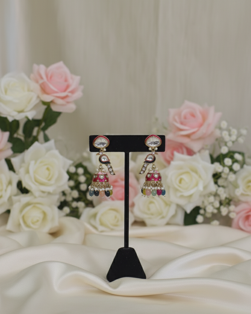 Pair of earrings on a stand with flowers in the background