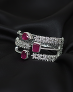 Silver bracelet with red gemstones on a black fabric background