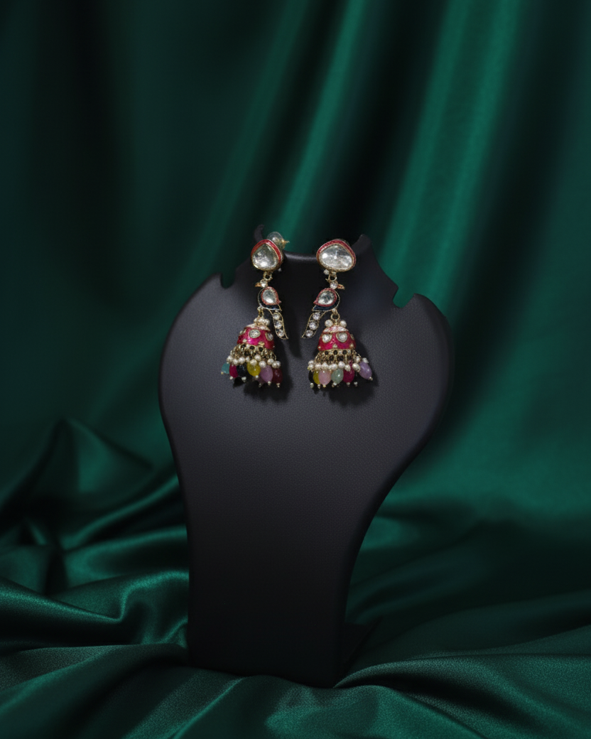 Earrings on a black stand against a green satin background