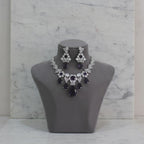 Jewelry set with necklace and earrings on a gray mannequin bust against a marble background