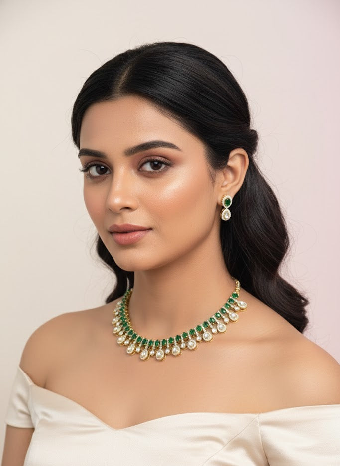 Woman wearing a green and gold necklace and earrings against a light pink background