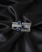 Pair of earrings with blue gemstones on a black satin background