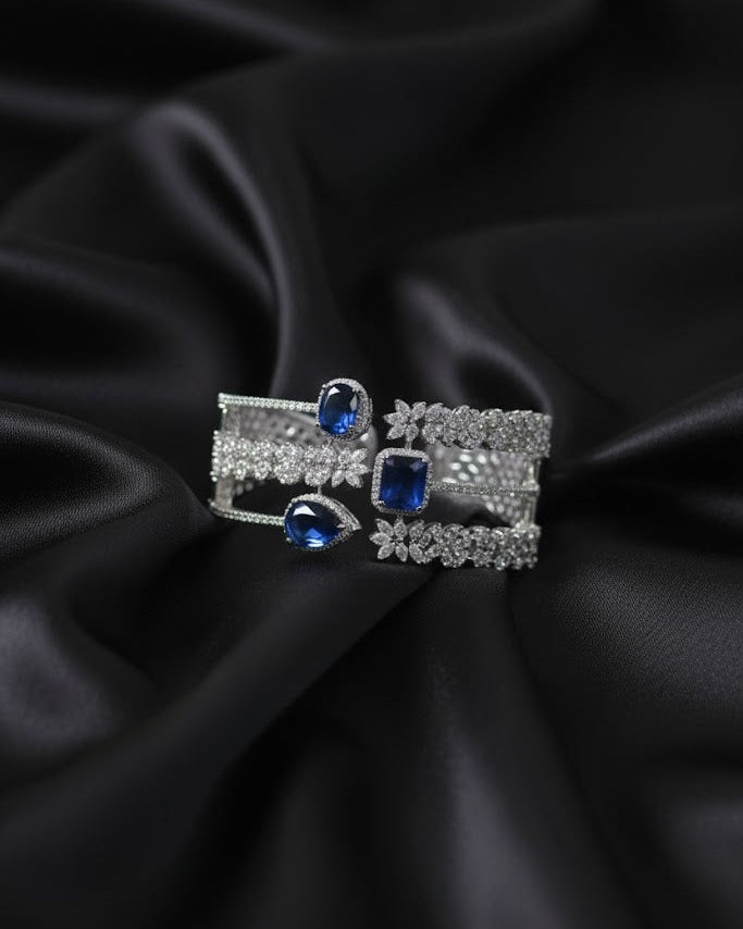 Pair of earrings with blue gemstones on a black satin background