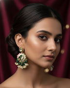 Woman wearing elaborate earrings against a red curtain background