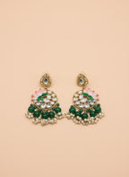 Pair of green and gold earrings with floral designs on a beige background