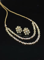 Gold necklace and earrings on a black background