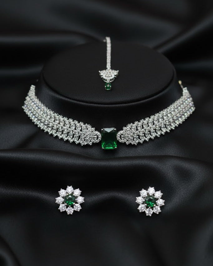 Jewelry set with necklace, earrings, and ring on a black satin background