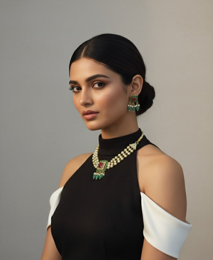 Woman wearing a black and white outfit with jewelry against a gray background