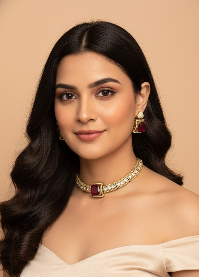 Woman wearing a gold necklace with red stones against a beige background