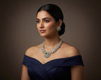 Woman wearing a diamond necklace and earrings against a dark background