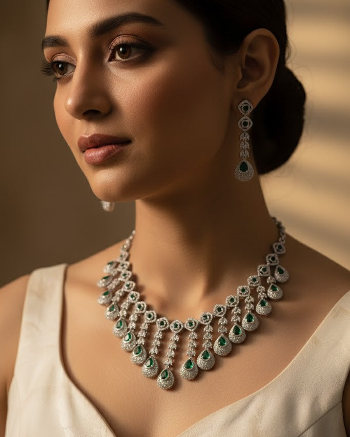 Woman wearing a luxurious diamond and emerald necklace with a neutral background