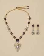 Ornate necklace and earrings set on a beige background
