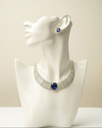 Necklace with blue stones on a white mannequin bust against a beige background