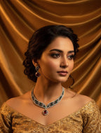 Woman wearing a gold embroidered outfit with a necklace against a brown curtain background