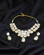 Pearl necklace and earrings set on a dark fabric background