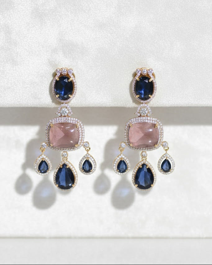Pair of earrings with blue and pink stones on a white background
