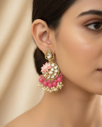 Close-up of a woman wearing a decorative earring with pink and gold details.