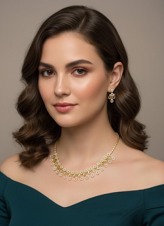Woman wearing a gold necklace and earrings against a neutral background